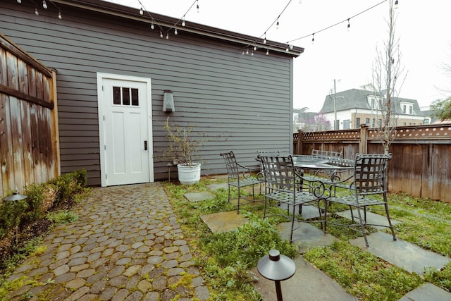 back of house featuring a patio, a fenced backyard, and outdoor dining space