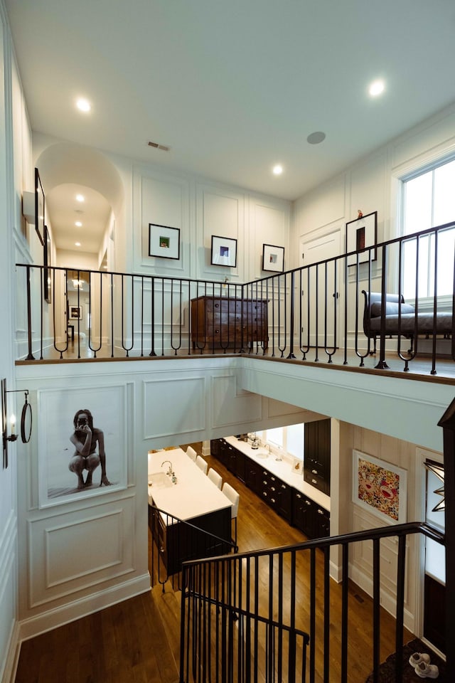 stairway featuring a decorative wall, visible vents, recessed lighting, and wood finished floors