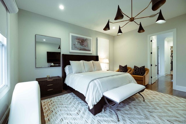 bedroom with baseboards, wood finished floors, and recessed lighting