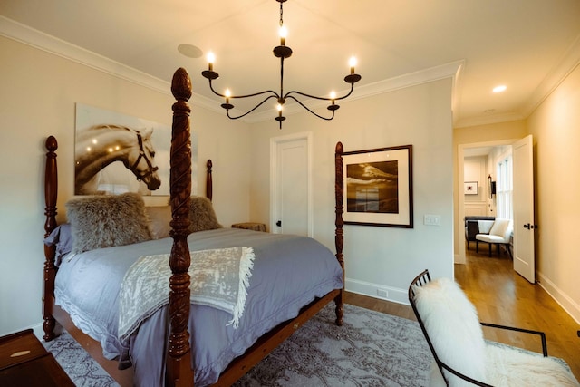 bedroom with an inviting chandelier, crown molding, baseboards, and wood finished floors