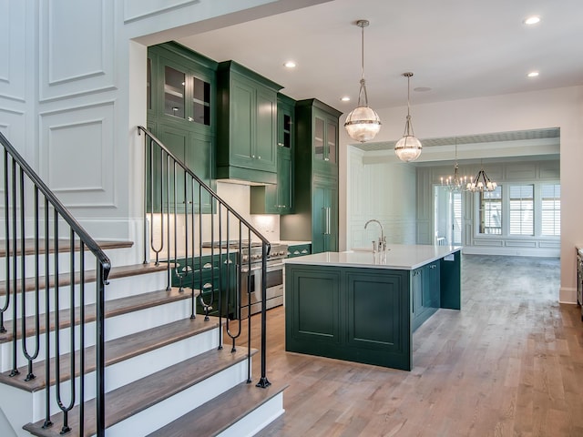 kitchen featuring green cabinetry, light countertops, light wood-style floors, and an inviting chandelier