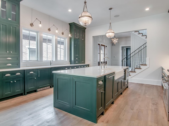kitchen with green cabinets, light countertops, and a sink