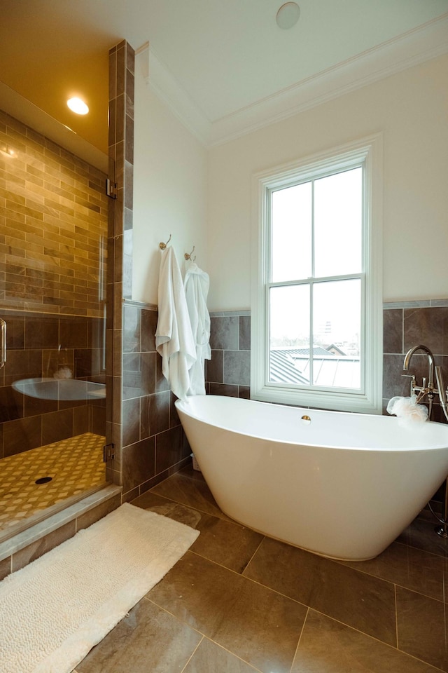 bathroom featuring tile walls, ornamental molding, a stall shower, and a freestanding bath