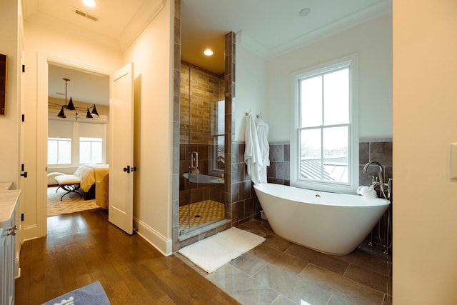 ensuite bathroom featuring ornamental molding, a stall shower, ensuite bath, and visible vents