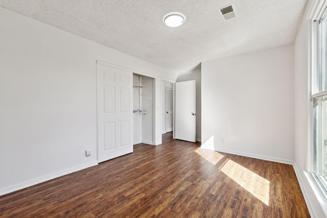 3049 Fieldstone Dr, Antioch, TN 37013 - unfurnished bedroom with a closet, a textured ceiling, baseboards, visible vents, and dark wood-type flooring