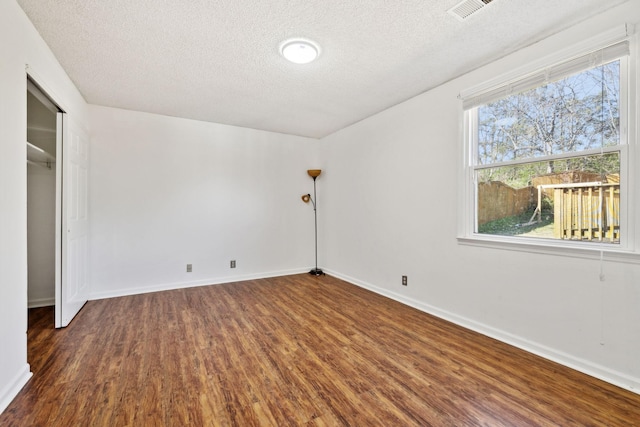 3049 Fieldstone Dr, Antioch, TN 37013 - unfurnished bedroom featuring dark wood-style floors, baseboards, a textured ceiling, and visible vents