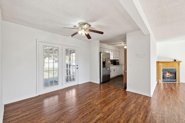 3049 Fieldstone Dr, Antioch, TN 37013 - unfurnished living room with dark wood-style flooring, a textured ceiling, a ceiling fan, and a lit fireplace