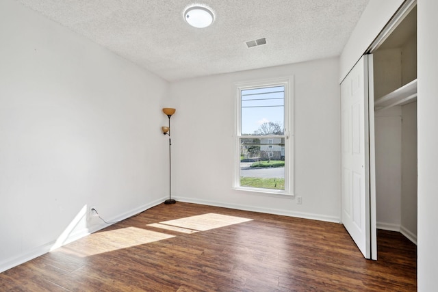 3049 Fieldstone Dr, Antioch, TN 37013 - unfurnished bedroom with a closet, wood finished floors, a textured ceiling, baseboards, and visible vents