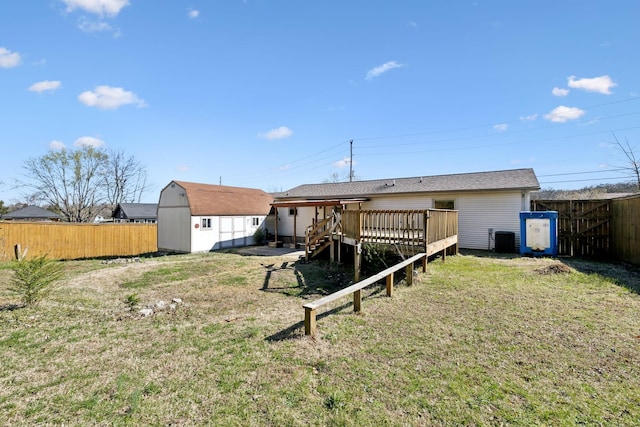3049 Fieldstone Dr, Antioch, TN 37013 - rear view of house with central air condition unit, fence, a wooden deck, a storage shed, and an outbuilding