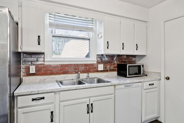 3049 Fieldstone Dr, Antioch, TN 37013 - kitchen featuring a textured ceiling, light countertops, appliances with stainless steel finishes, white cabinetry, and a sink