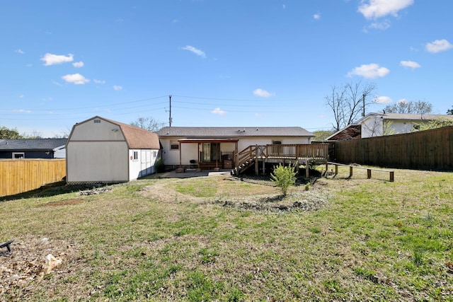 3049 Fieldstone Dr, Antioch, TN 37013 - back of house featuring a wooden deck, an outdoor structure, a fenced backyard, a storage unit, and a lawn