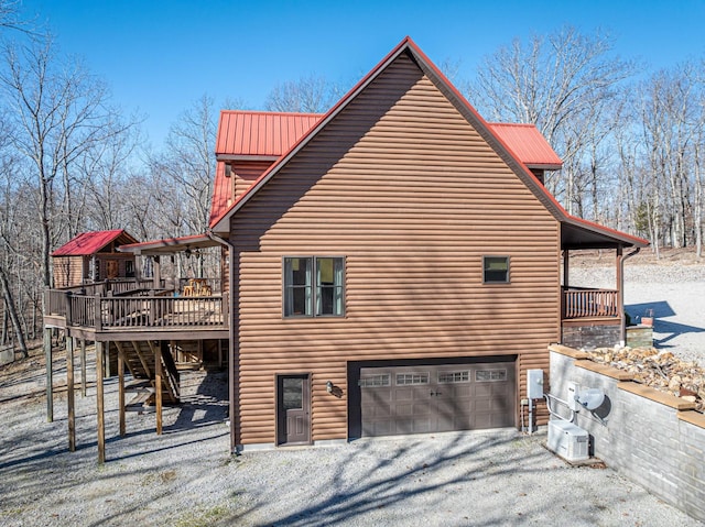 576 Ridgeway Dr, Sugar Tree, TN 38380 - view of property exterior with metal roof, gravel driveway, a wooden deck, and a garage