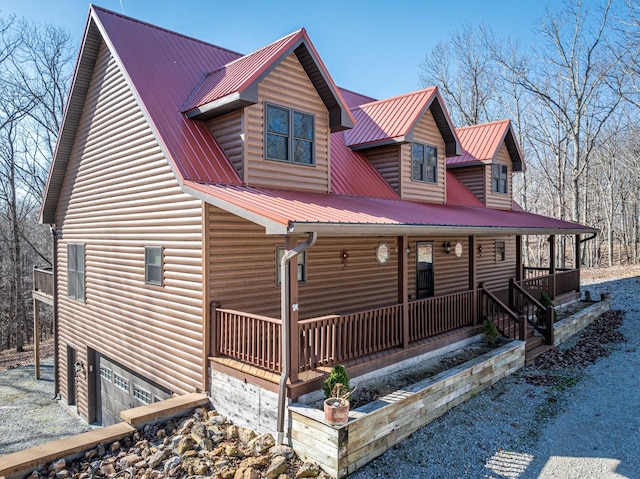 576 Ridgeway Dr, Sugar Tree, TN 38380 - rustic home with an attached garage, metal roof, covered porch, and log veneer siding