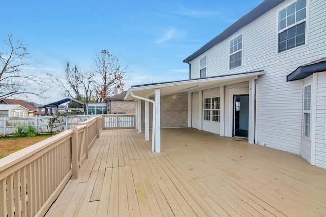 deck with an attached carport and fence