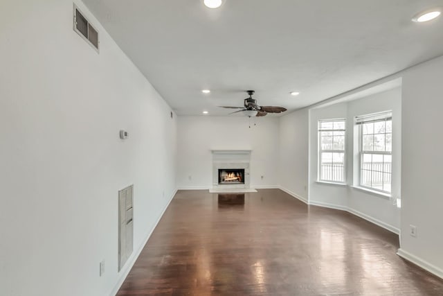 unfurnished living room featuring a warm lit fireplace, visible vents, recessed lighting, and a ceiling fan