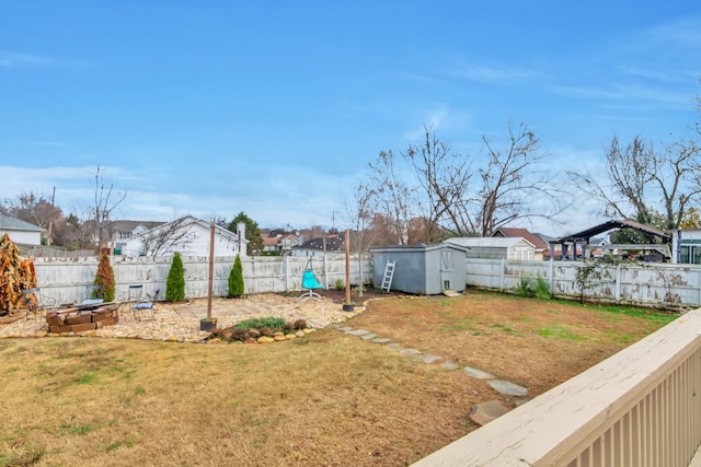 view of yard with a fenced backyard, a residential view, an outdoor structure, and a storage shed