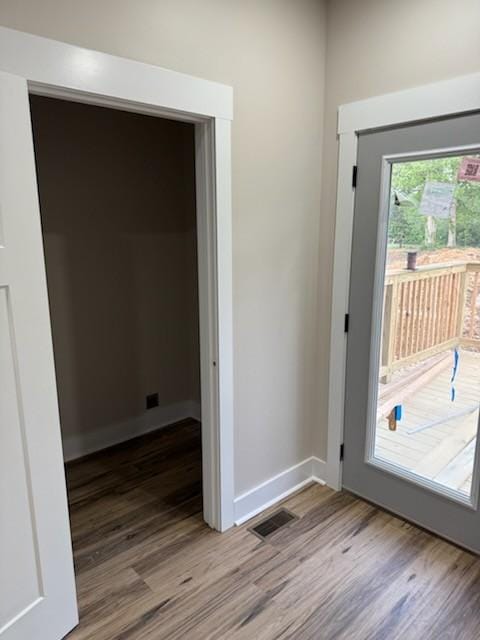 entryway featuring baseboards, wood finished floors, and visible vents
