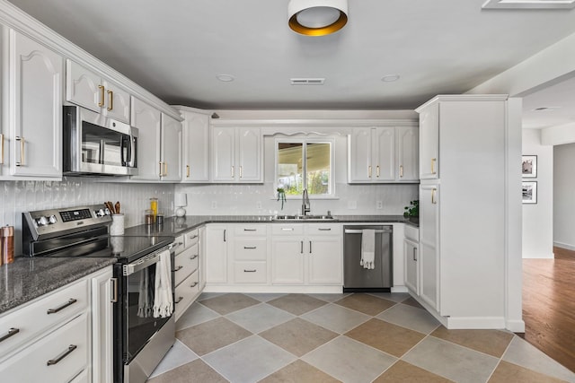 234 Spring St, La Vergne, TN 37086 - kitchen featuring a sink, appliances with stainless steel finishes, white cabinets, and decorative backsplash