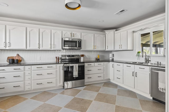 234 Spring St, La Vergne, TN 37086 - kitchen with decorative backsplash, visible vents, a sink, white cabinets, and stainless steel appliances