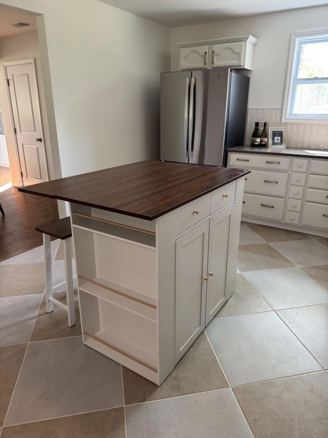 234 Spring St, La Vergne, TN 37086 - kitchen featuring backsplash, a kitchen island, freestanding refrigerator, butcher block counters, and white cabinetry
