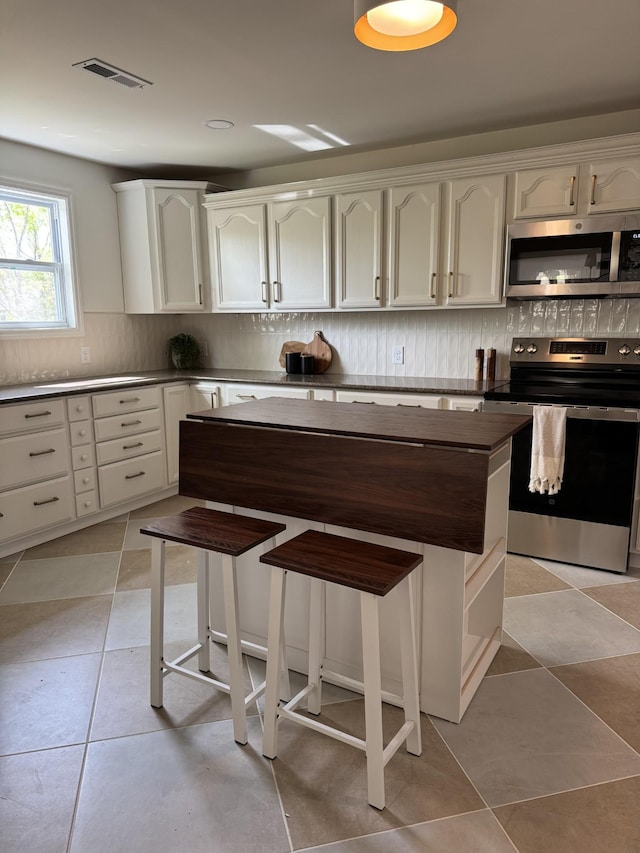 234 Spring St, La Vergne, TN 37086 - kitchen with white cabinets, backsplash, stainless steel appliances, and visible vents