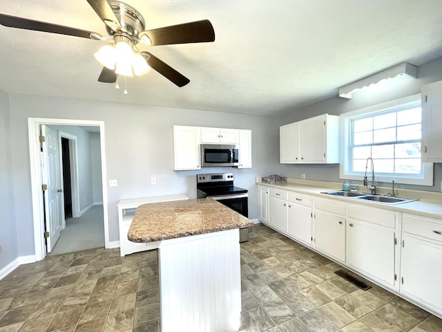 1088 Poole Mill Rd, Crofton, KY 42217 - kitchen with a sink, a kitchen island, a ceiling fan, white cabinetry, and appliances with stainless steel finishes