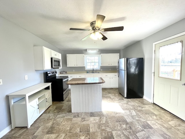 1088 Poole Mill Rd, Crofton, KY 42217 - kitchen featuring a kitchen island, white cabinetry, ceiling fan, and stainless steel appliances