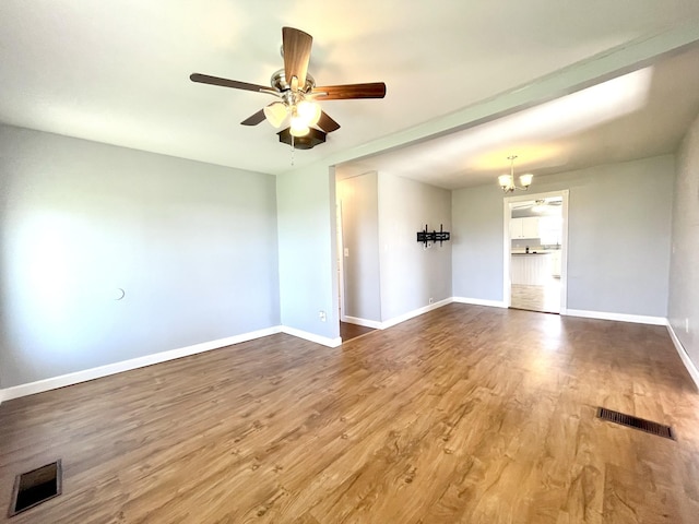 1088 Poole Mill Rd, Crofton, KY 42217 - empty room featuring ceiling fan with notable chandelier, visible vents, wood finished floors, and baseboards