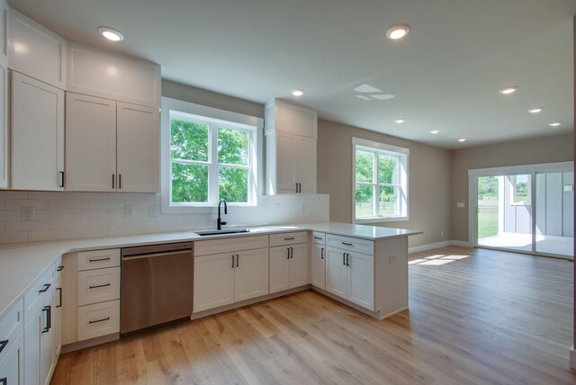 1151 Canaan Rd, Columbia, TN 38401 - kitchen with stainless steel dishwasher, a sink, a peninsula, tasteful backsplash, and light wood-style floors
