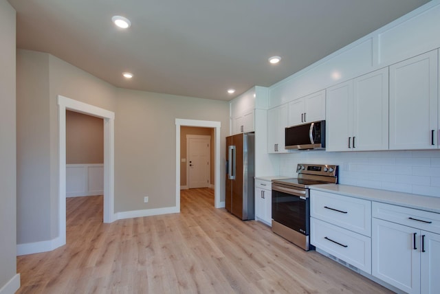 1151 Canaan Rd, Columbia, TN 38401 - kitchen featuring stainless steel appliances, backsplash, light wood-style floors, light countertops, and white cabinetry