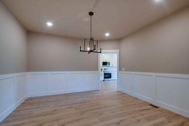 1151 Canaan Rd, Columbia, TN 38401 - unfurnished dining area with a decorative wall, a chandelier, recessed lighting, light wood-style floors, and wainscoting