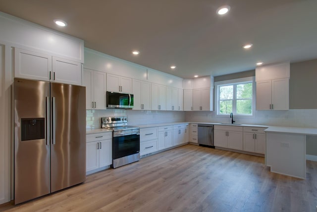 1151 Canaan Rd, Columbia, TN 38401 - kitchen with stainless steel appliances, a sink, light countertops, decorative backsplash, and white cabinets