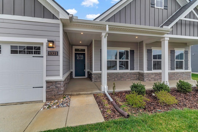property entrance featuring board and batten siding, stone siding, and covered porch