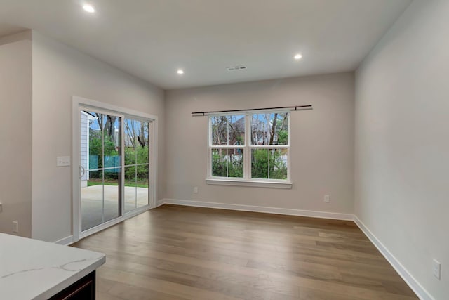 unfurnished dining area featuring wood finished floors, recessed lighting, and baseboards