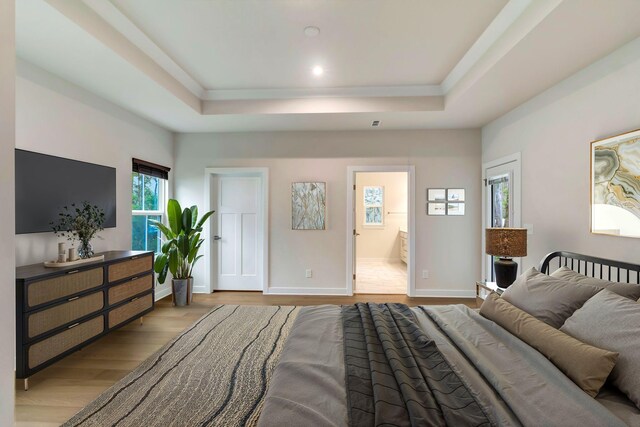 bedroom featuring a tray ceiling, wood finished floors, baseboards, connected bathroom, and recessed lighting