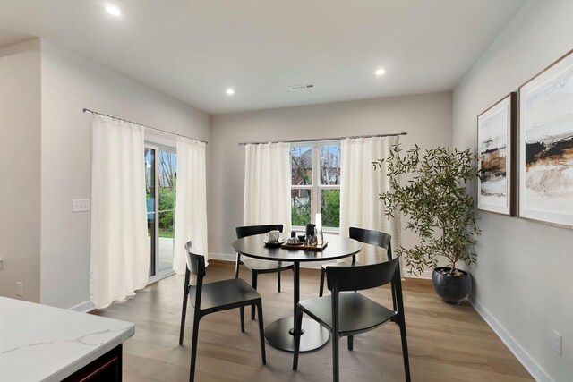 dining room featuring plenty of natural light, wood finished floors, recessed lighting, and baseboards