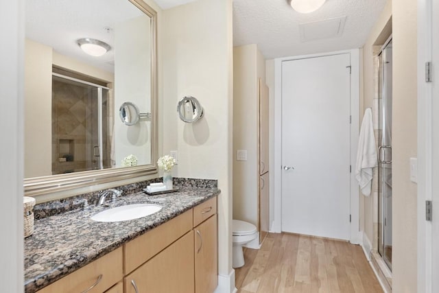 2600 Hillsboro Pike Unit 204, Nashville, TN 37212 - bathroom with toilet, vanity, a shower stall, wood finished floors, and a textured ceiling