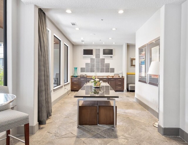 2600 Hillsboro Pike Unit 204, Nashville, TN 37212 - interior space featuring a center island, a textured ceiling, dark brown cabinetry, and visible vents