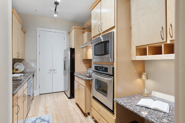 2600 Hillsboro Pike Unit 204, Nashville, TN 37212 - kitchen featuring decorative backsplash, light stone counters, light brown cabinetry, and appliances with stainless steel finishes