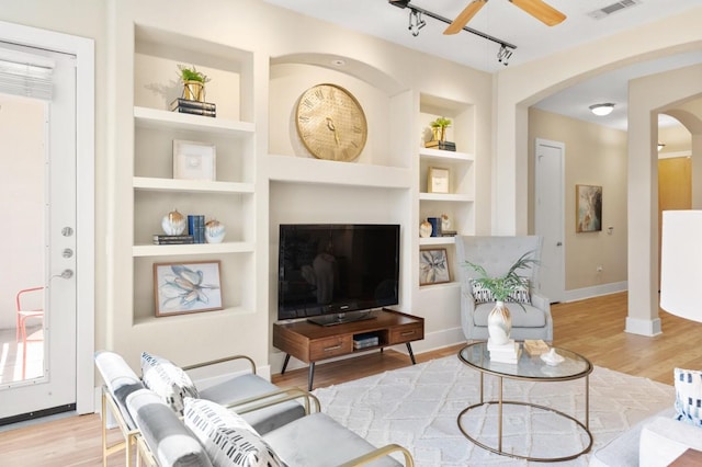 2600 Hillsboro Pike Unit 204, Nashville, TN 37212 - living room featuring arched walkways, built in shelves, visible vents, and light wood finished floors