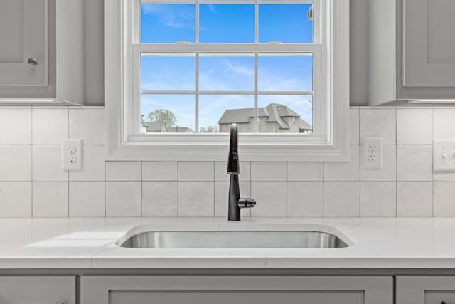 1121 Joe Martin Ln, Lebanon, TN 37087 - details with gray cabinets, light countertops, a sink, and tasteful backsplash
