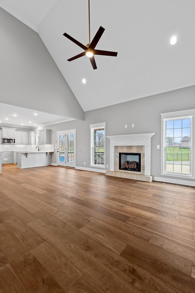 1121 Joe Martin Ln, Lebanon, TN 37087 - unfurnished living room featuring baseboards, ceiling fan, a tiled fireplace, and light wood finished floors