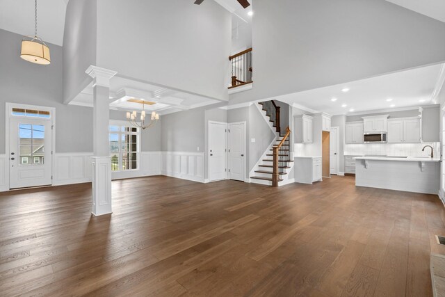 1121 Joe Martin Ln, Lebanon, TN 37087 - unfurnished living room featuring a sink, stairway, dark wood-style floors, wainscoting, and ceiling fan with notable chandelier