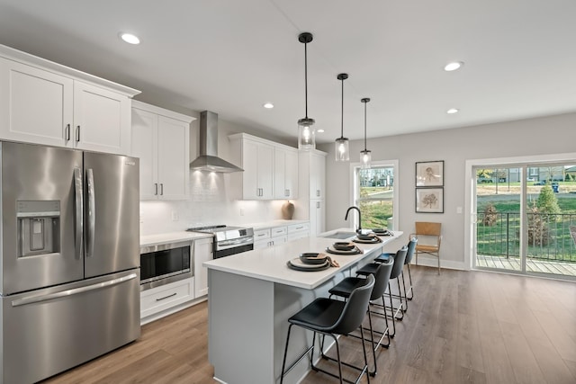 205 Charlotte Everly Cir, Hendersonville, TN 37075 - kitchen featuring light countertops, tasteful backsplash, a center island with sink, wall chimney range hood, and appliances with stainless steel finishes