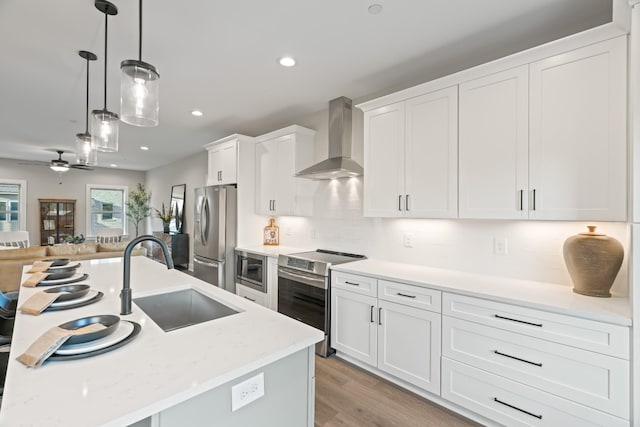205 Charlotte Everly Cir, Hendersonville, TN 37075 - kitchen with white cabinetry, decorative light fixtures, a sink, wall chimney range hood, and appliances with stainless steel finishes