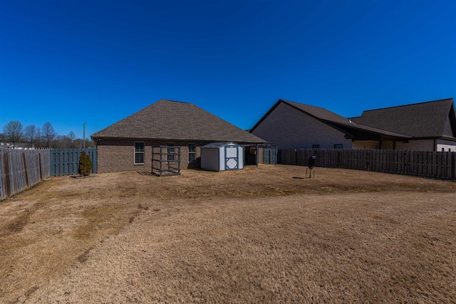 view of yard featuring an outdoor structure, a fenced backyard, and a storage shed