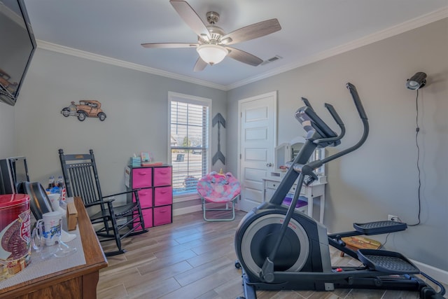 exercise room with baseboards, ornamental molding, wood finished floors, and ceiling fan