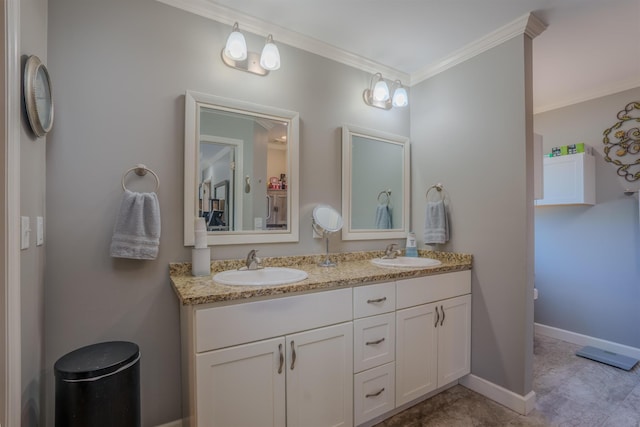 full bath featuring baseboards, double vanity, ornamental molding, and a sink