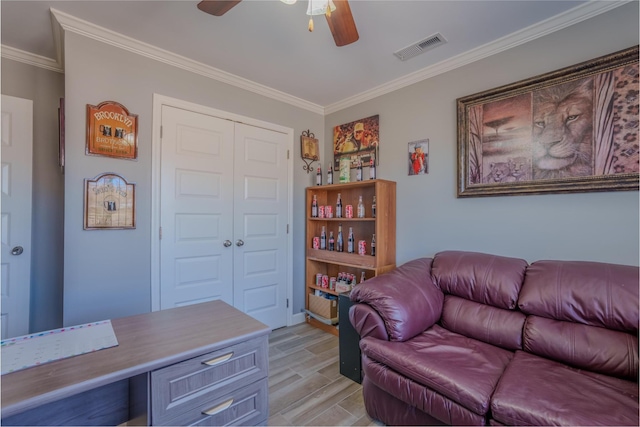 office area featuring light wood finished floors, visible vents, crown molding, and ceiling fan