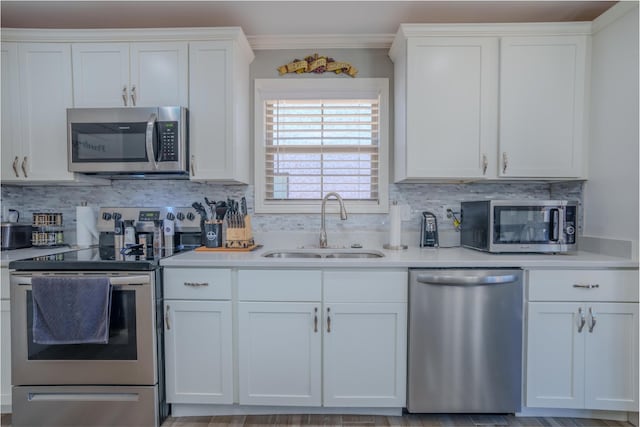 kitchen featuring light countertops, a sink, stainless steel appliances, and white cabinets